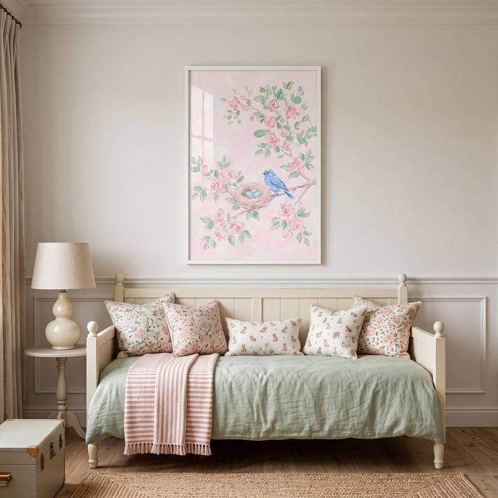 Framed pink floral blue bird wall art hangs above a daybed with patterned pillows and a sage green coverlet.