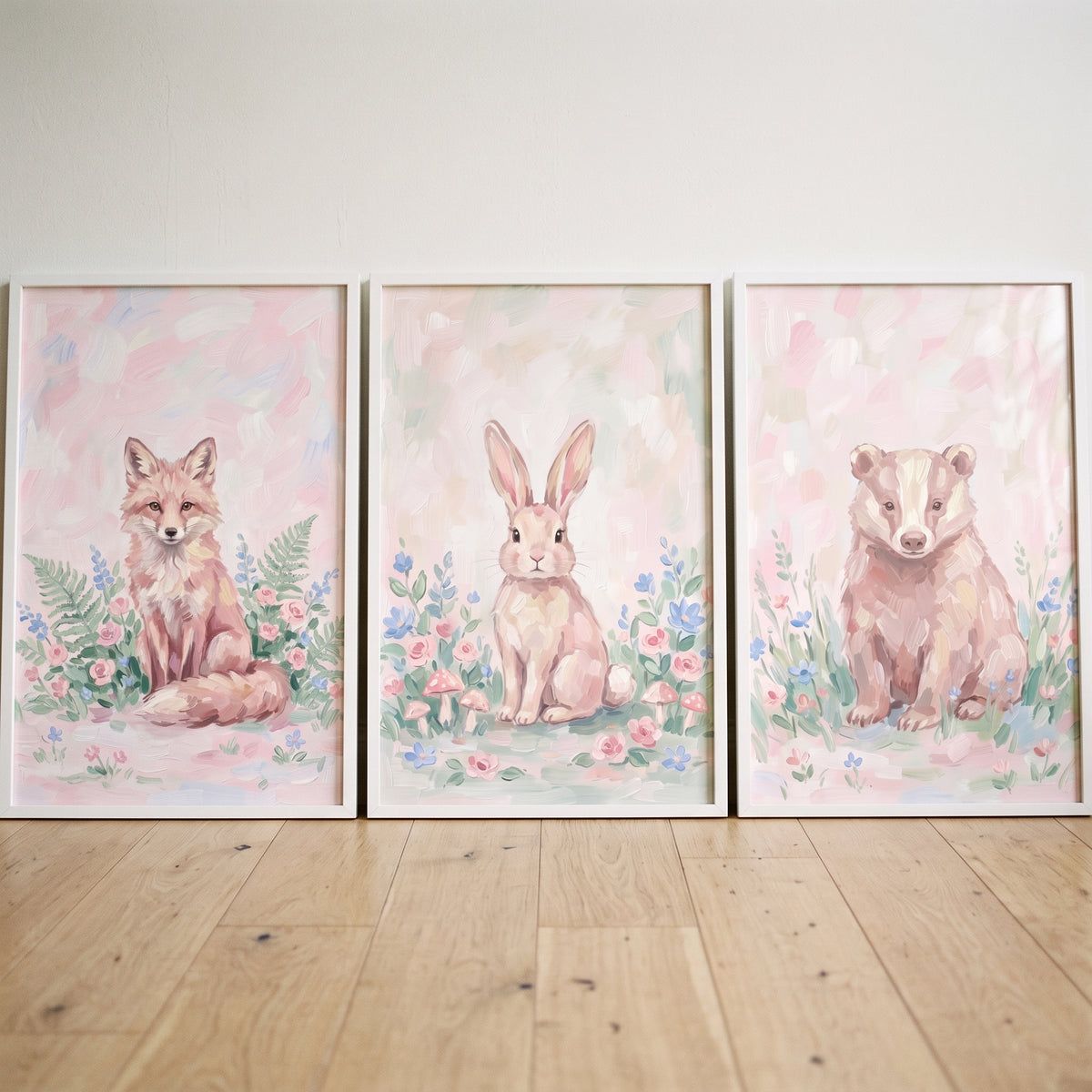 Pink floral forest animals wall art set of 3 with a fox, rabbit, and badger sitting among pastel wildflowers.