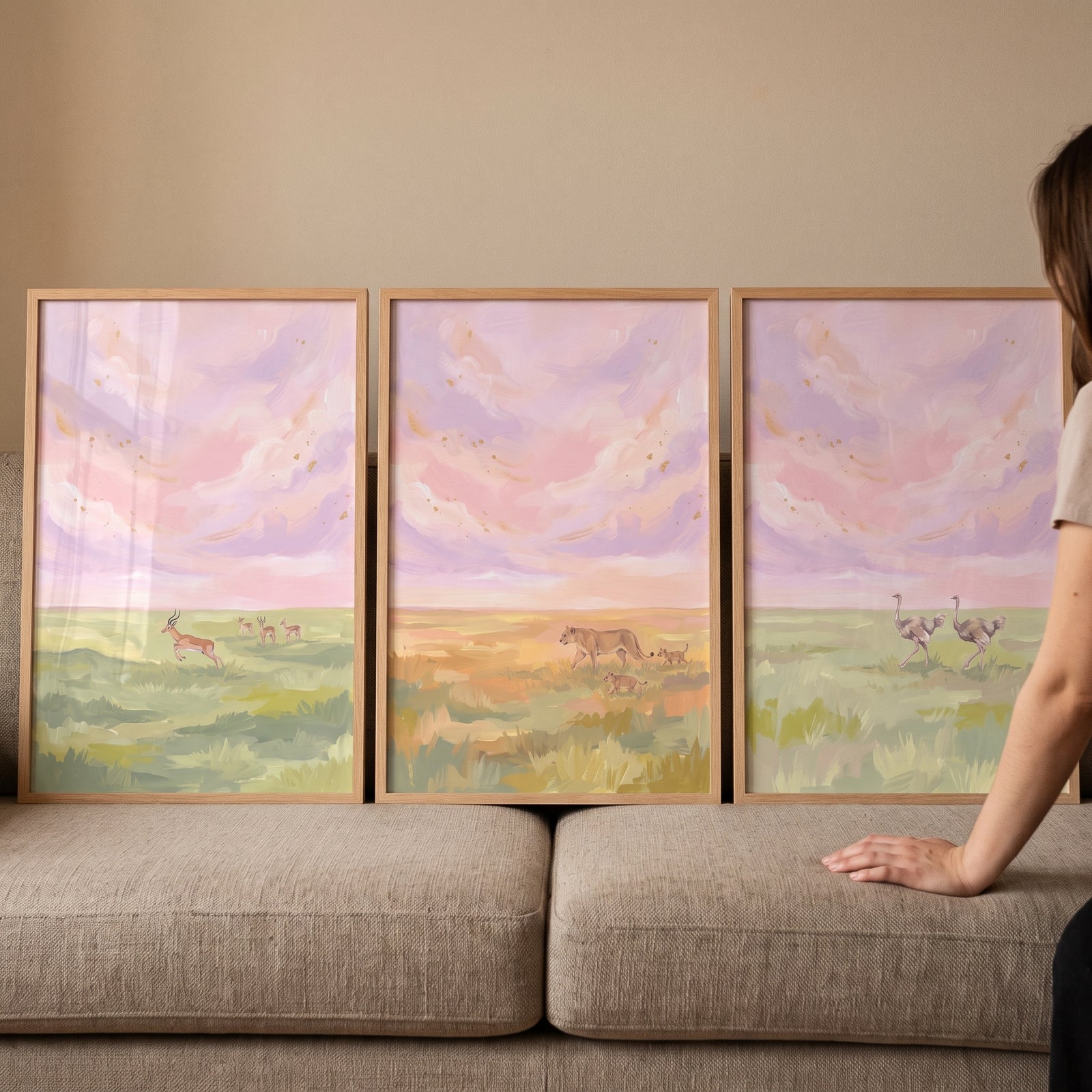 Pink gold flecked safari animals print set of 3 with gazelles, lions, and ostriches displayed on a fabric couch.