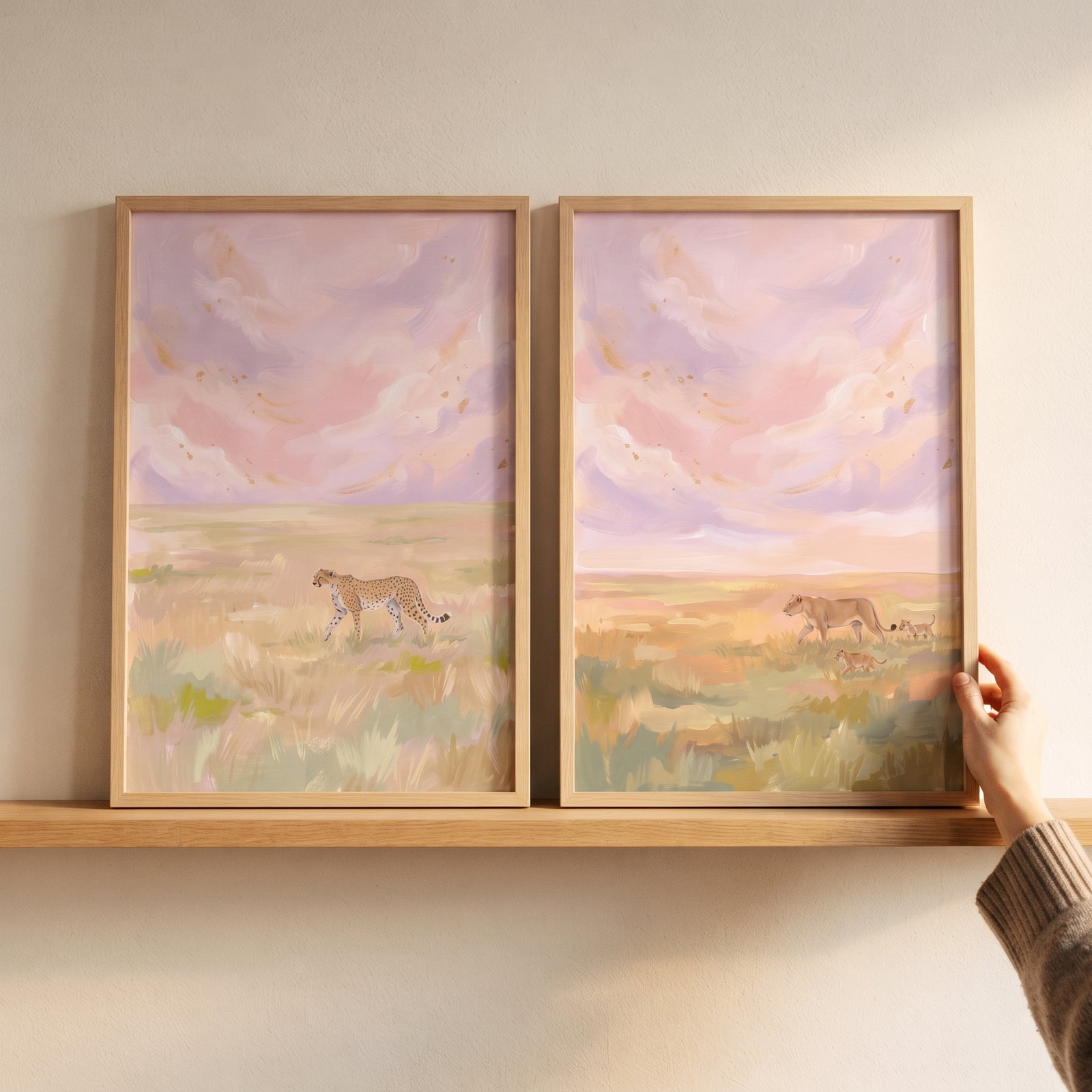 Pink lavender safari cat wall art set of 2 featuring a cheetah and lions, displayed on a wooden shelf.
