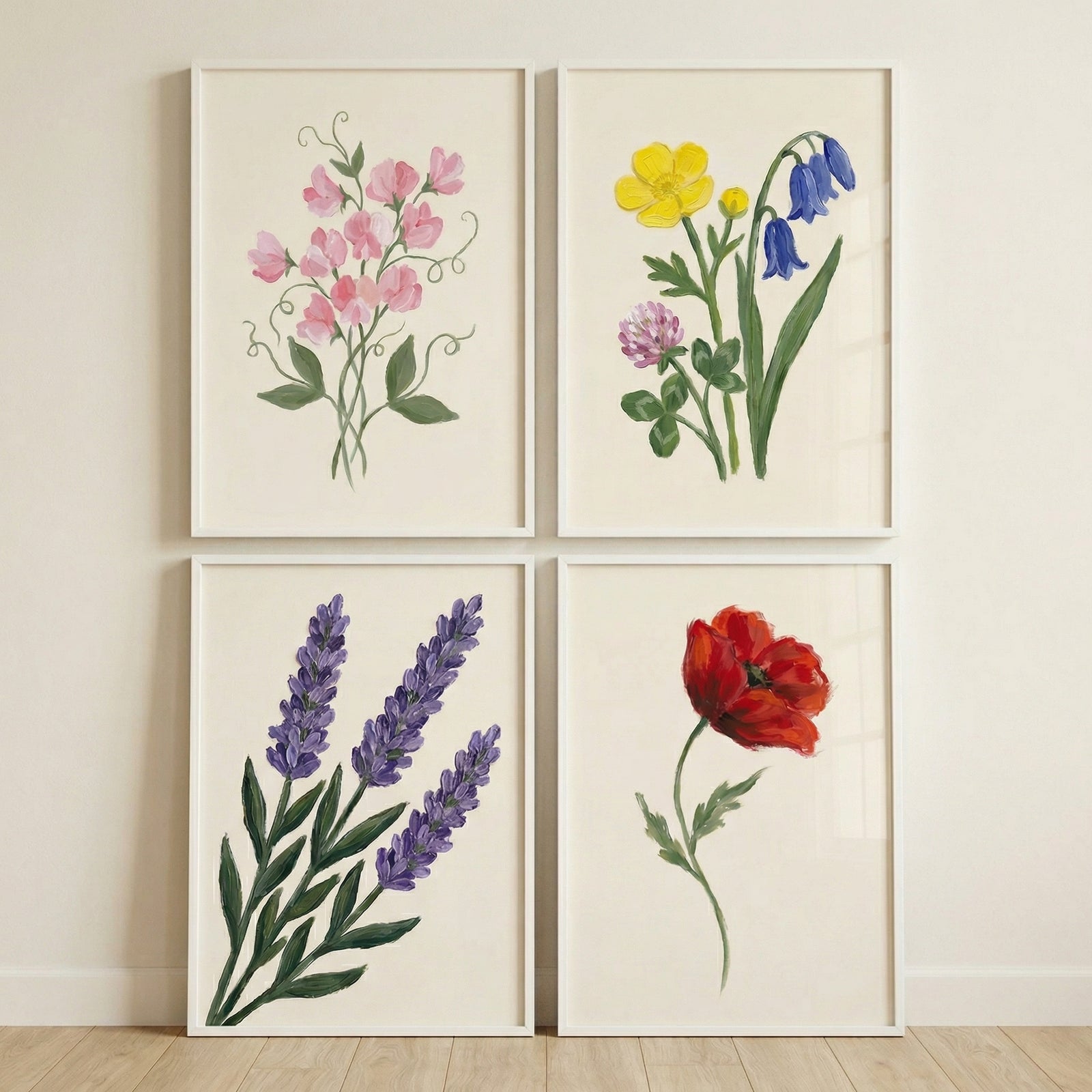 Four framed botanical prints arranged in a grid featuring pink sweet pea flowers colorful wildflowers purple lavender and a single red poppy each painted in a soft hand painted style on a light background.