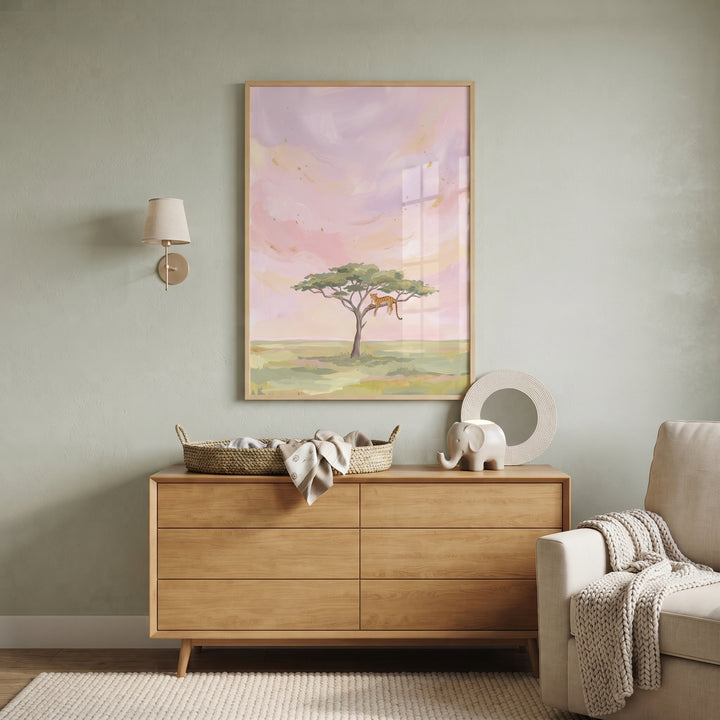 Pink sky lounging leopard animal wall art hangs above a wooden dresser in a neutral-toned nursery with an armchair.