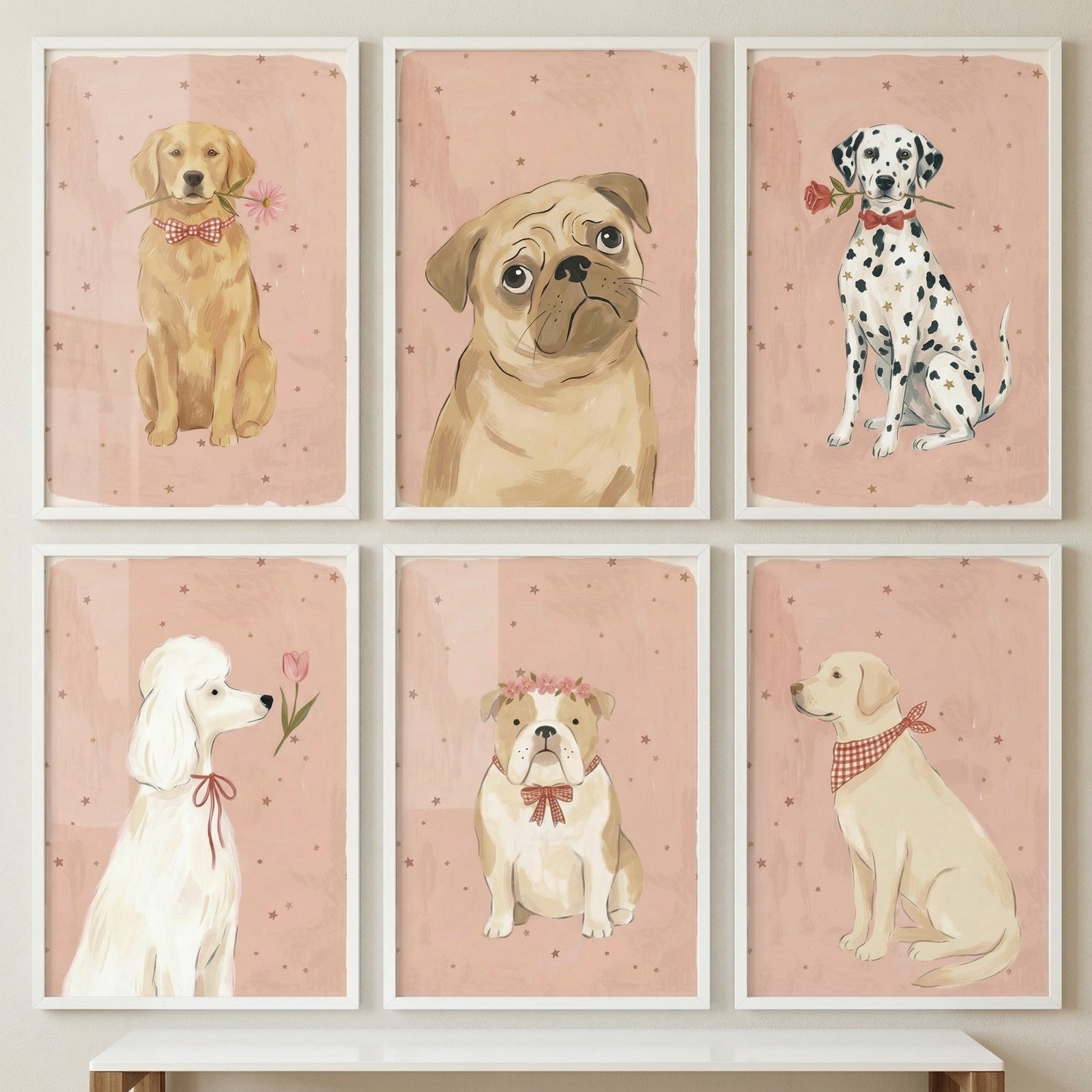Six framed dog illustrations are displayed in a three-by-two grid on a neutral wall above a rustic wooden shelf. Each portrait features a dog against a textured pink backdrop adorned with small, scattered brown dots and a soft white border.
