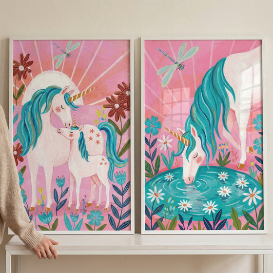 Pink sunburst teal unicorn wall art set of 2 showing unicorns with flowers and dragonflies in white frames.