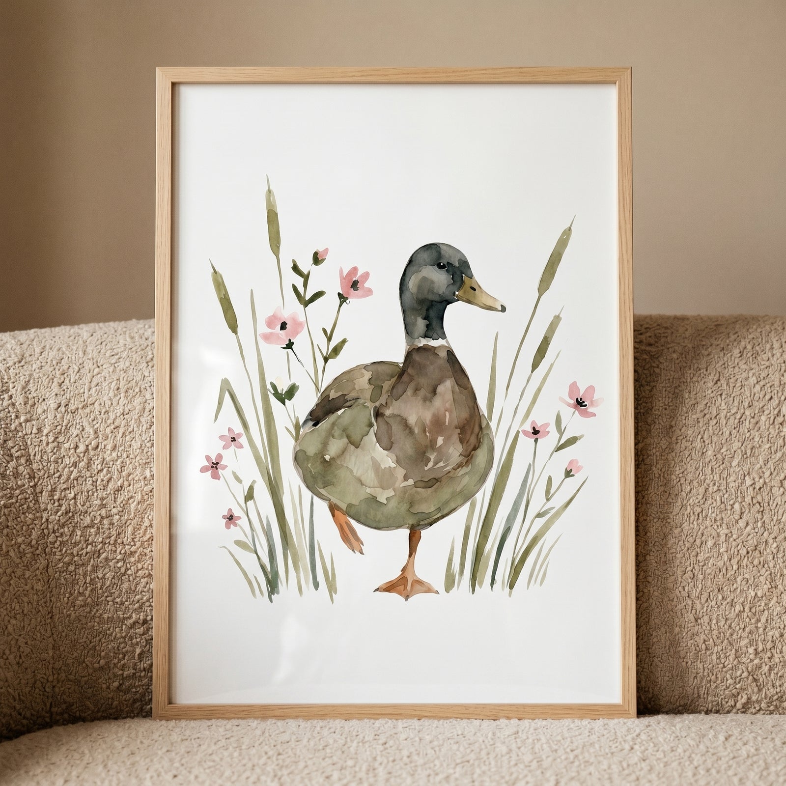 Framed pink wildflower mallard duck wall art shows a duck standing among tall green reeds and small pink blossoms.