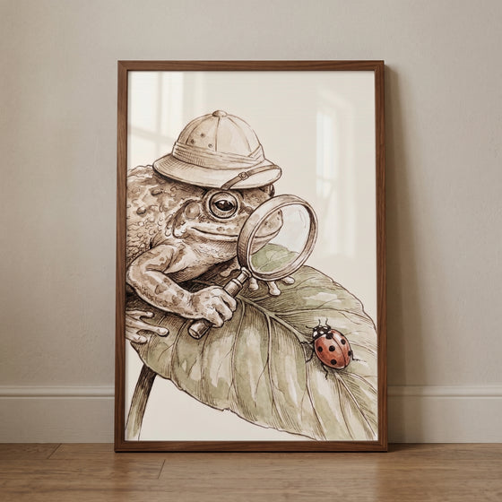 Pith helmet explorer toad wall art features a toad using a magnifying glass to look at a ladybug on a leaf.