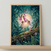 framed storybook-style illustration of two delicate fairies standing on a mossy log in a lush forest, facing each other beneath glowing pink foxglove flowers, with soft wings, gentle expressions, and a warm halo of light creating a magical, whimsical woodland scene.