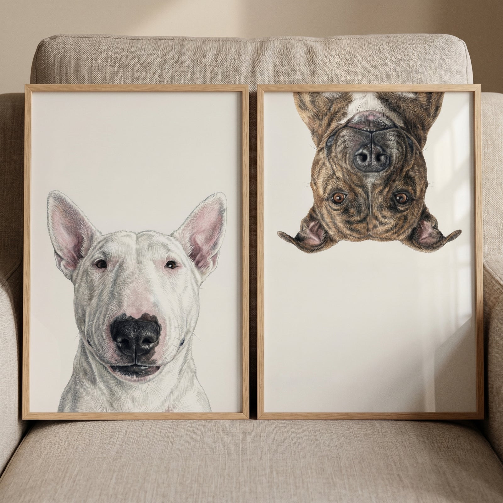 Playful realistic pet dog wall art set of 2 with a white bull terrier and an upside-down brindle dog on a couch.