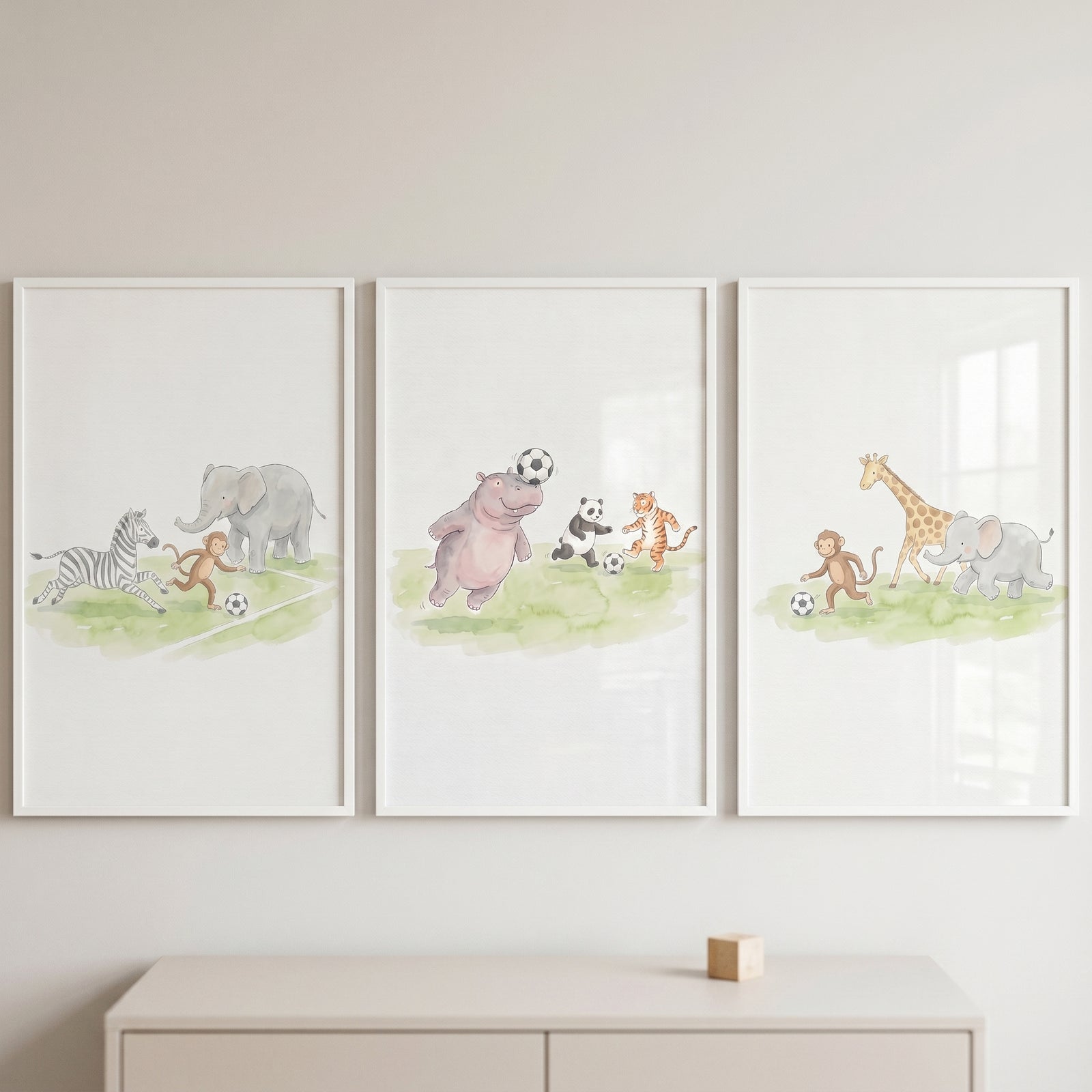 Playful soccer safari animals wall art set of 3 featuring watercolor wild animals playing on a grassy field.