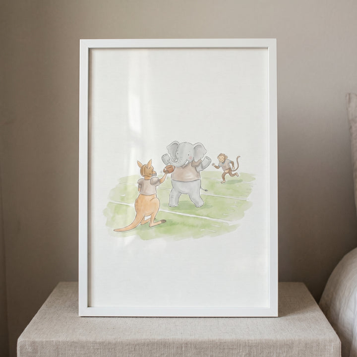 Framed playing football animals print of a kangaroo, elephant, and monkey on a green field.