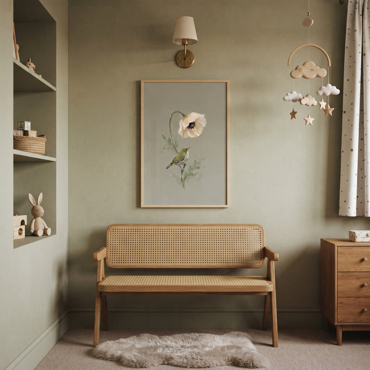 Sage green nursery featuring a cane bench, wooden dresser, star mobile, and poppy white eye bird wall art.