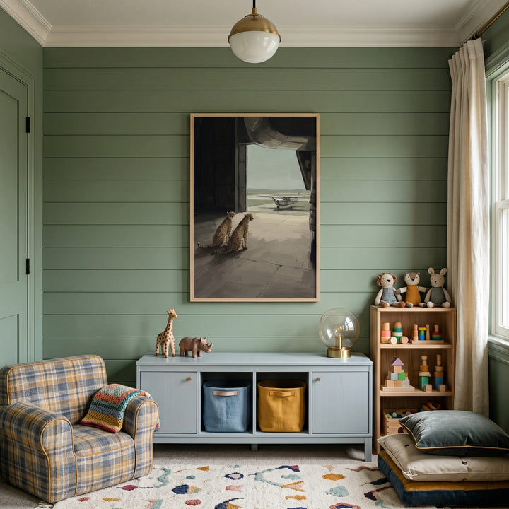 Green paneled room with a plaid chair, toy storage, and propeller plane watching cheetah artwork on the wall.