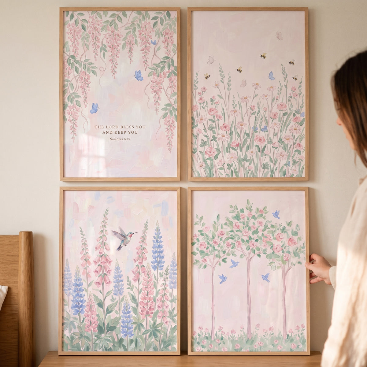 Provincial pink garden wall art set of 4 floral prints with birds and bees in light wood frames on a wall.