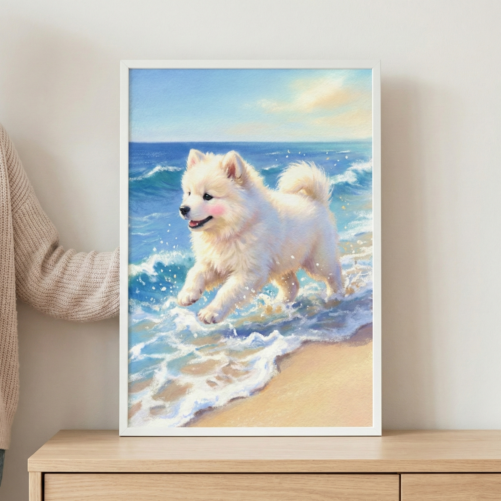 A vertical framed artwork depicts a fluffy white dog joyfully running through the surf on a sunlit beach. The dog has a happy expression and subtle pink cheeks, with its paws splashing in the frothy white waves. The background shows a vast blue ocean meeting a bright, clear sky. The style is soft and textured, using expressive strokes to create a gentle, warm atmosphere. The image is housed in a clean white frame and placed on a wooden surface against a neutral-colored wall.