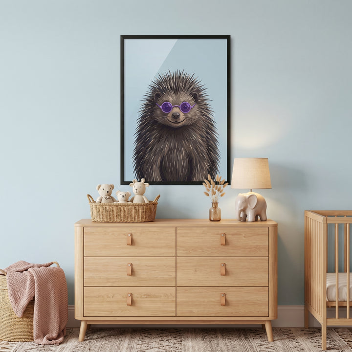Purple round glasses hedgehog wall art hangs over a wooden dresser in a blue nursery room with a crib and elephant lamp.