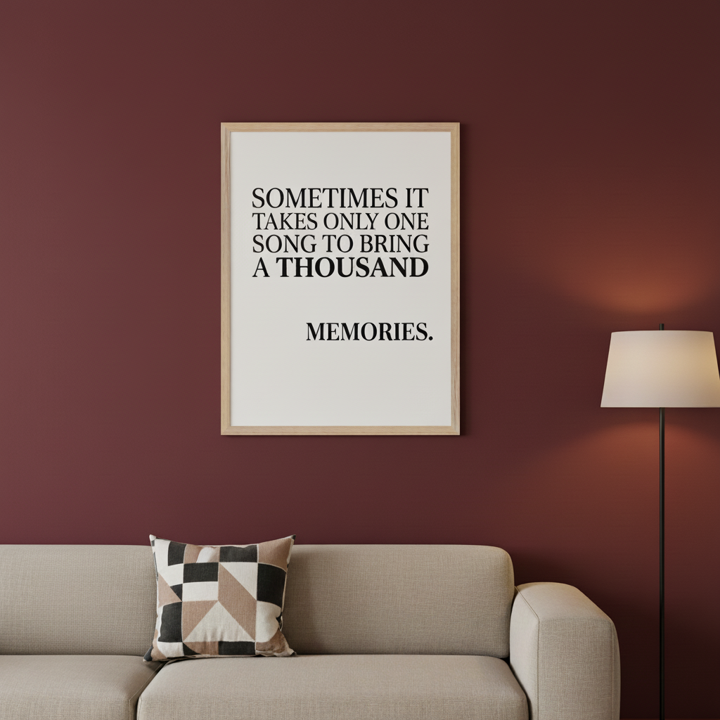 Modern living room with a burgundy wall. A beige sofa with a geometric pillow and a black floor lamp are visible. A framed poster above the sofa displays the text: "SOMETIMES IT TAKES ONLY ONE SONG TO BRING A THOUSAND MEMORIES."