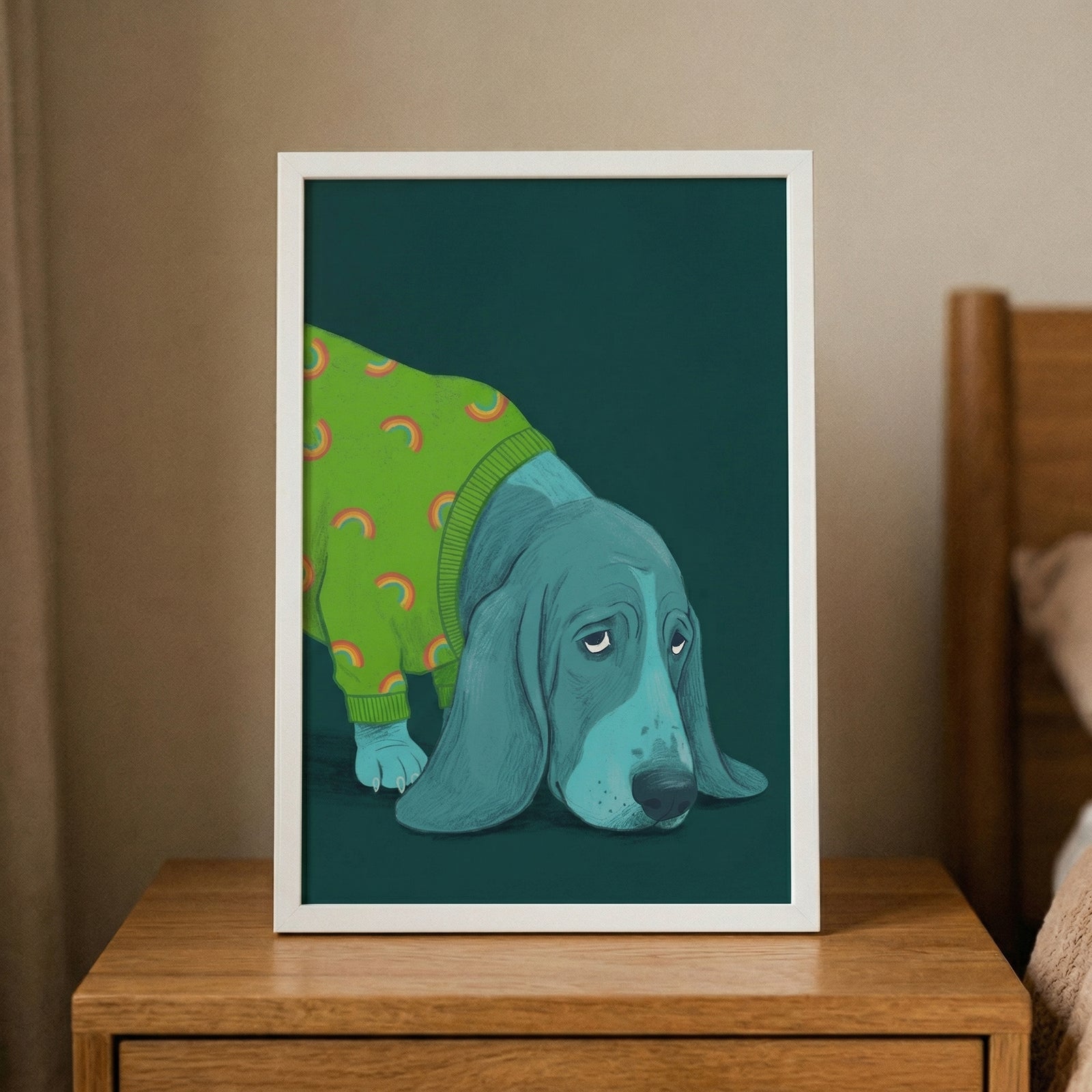 A vertical framed illustration of a blue-toned hound dog with long, drooping ears. The dog is depicted wearing a bright lime green sweater adorned with a repeating pattern of orange and yellow rainbows. Its head is lowered, and its expression appears melancholic, with heavy-lidded, tired eyes. The background within the white frame is a solid, dark emerald green. 