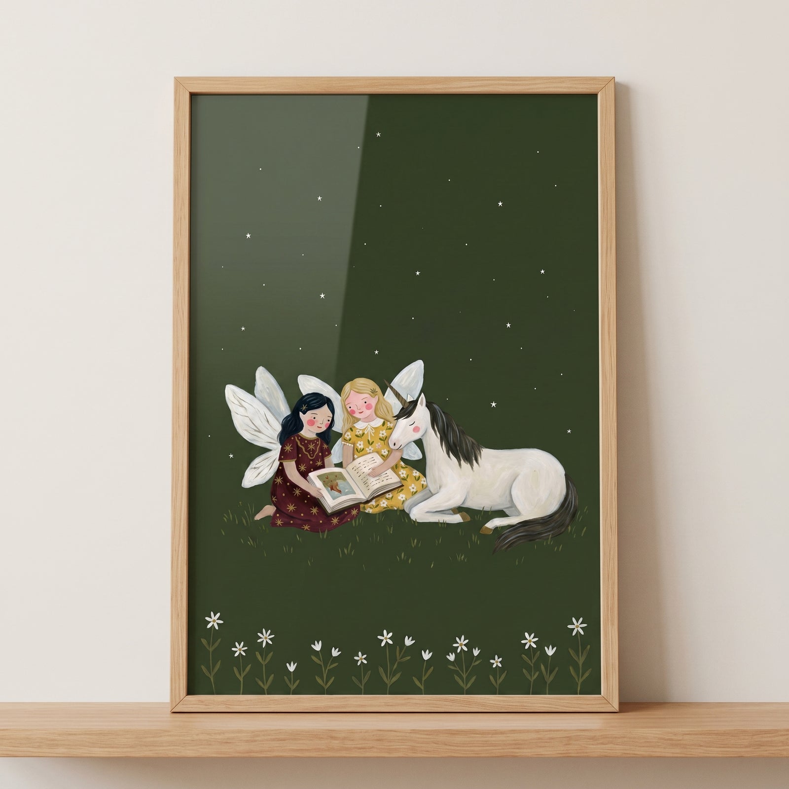 Framed reading storybook unicorn fairies wall art with two fairies and a unicorn reading under a starry night sky.