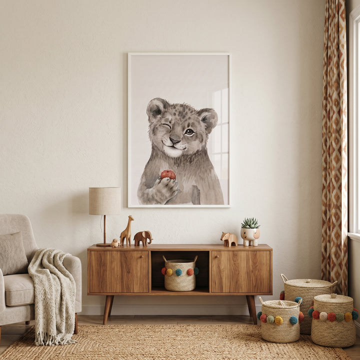 red apple leopard cub wall art above a wooden cabinet in a neutral nursery with animal toys and woven baskets.