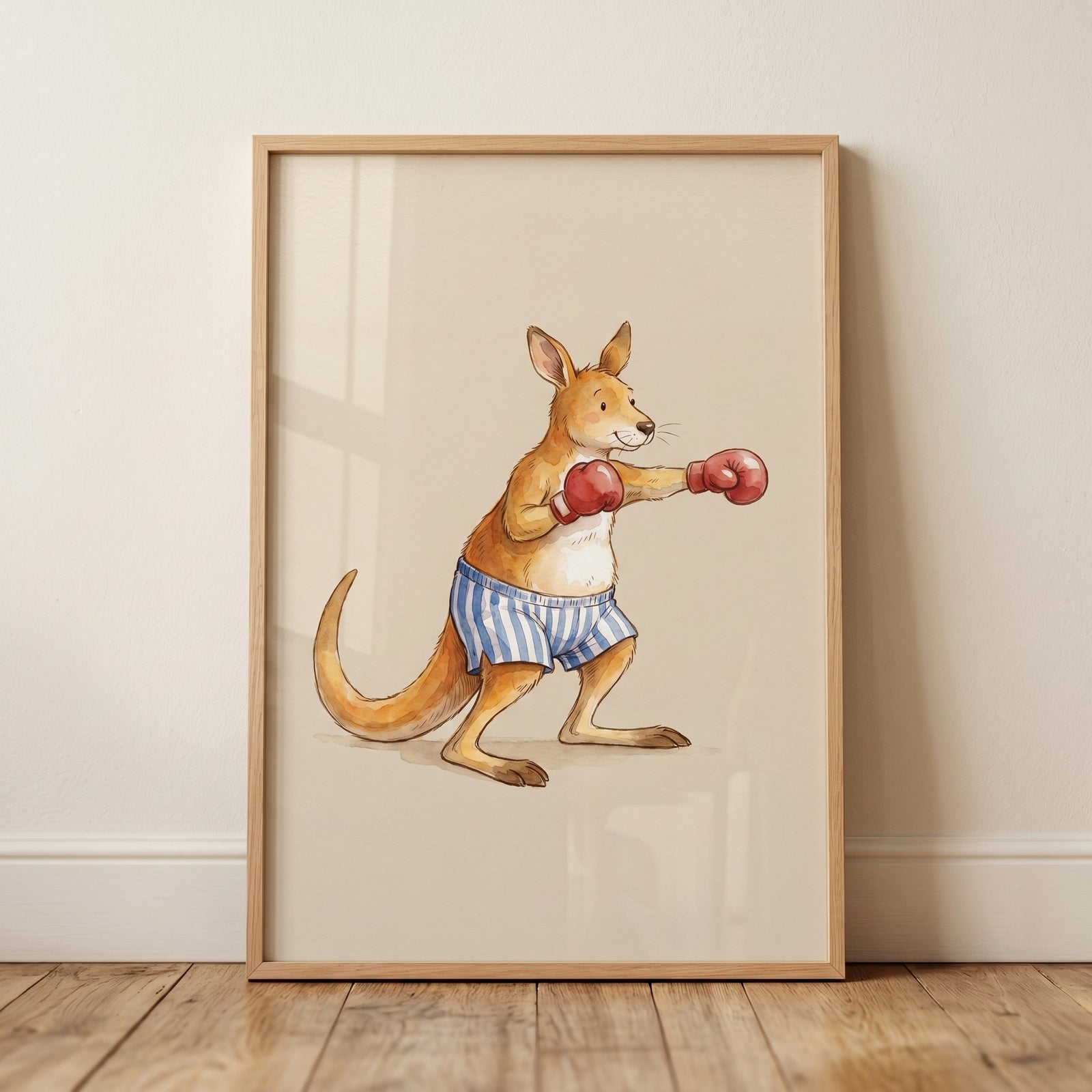 Framed red boxing gloves kangaroo wall art of a whimsical animal in striped shorts leaning against a beige wall.