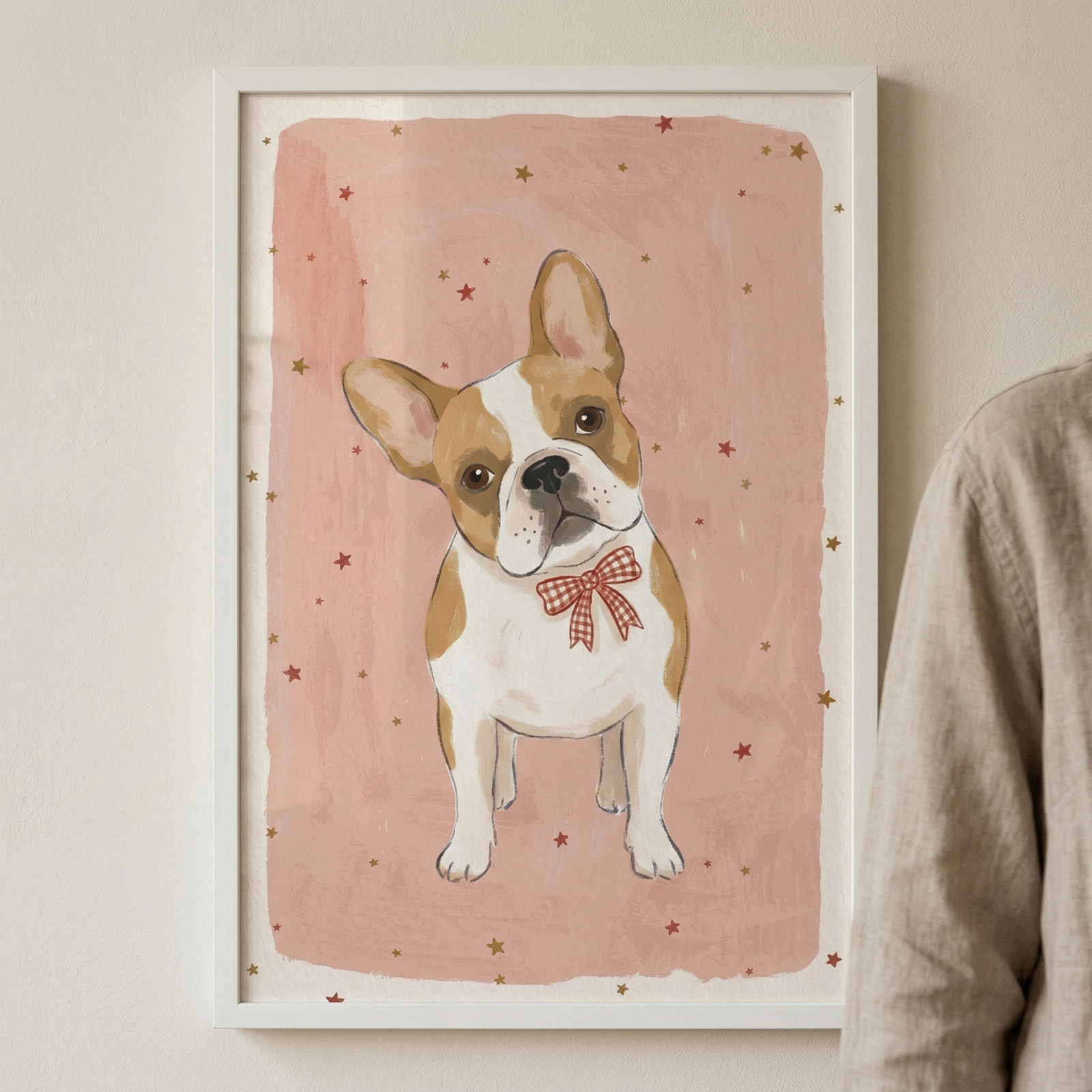 A vertical illustration features a small, white and light brown French Bulldog centered on a soft pink, textured background. The dog has large, rounded ears and dark, expressive eyes, looking forward with its head slightly tilted. It wears a red and white checkered bow tie around its neck. The background has a painterly appearance in a muted peach tone, accented by tiny, scattered gold and red stars. 