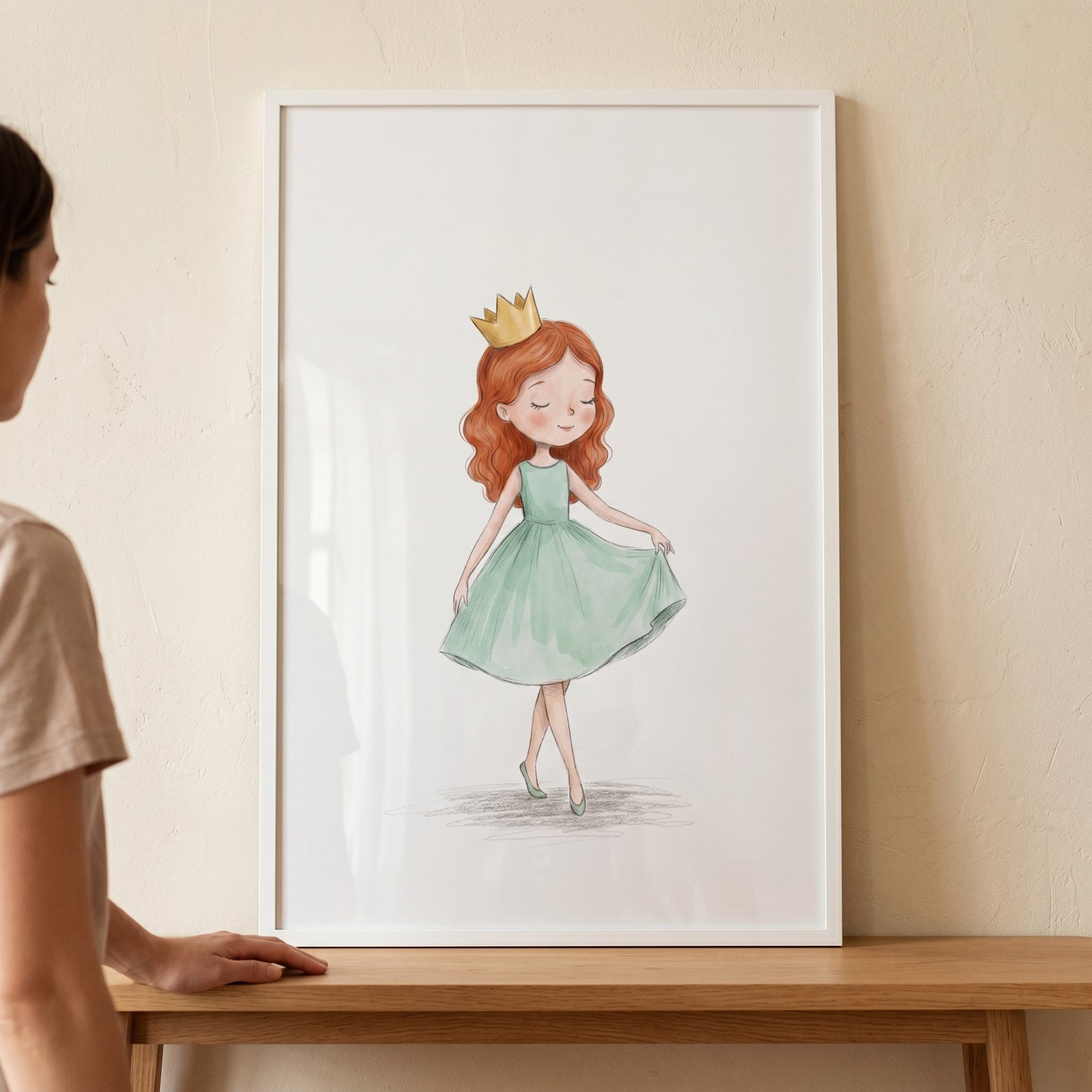 Framed red hair crown girl wall art shows a girl in a green dress, displayed on a wooden table against a neutral wall.