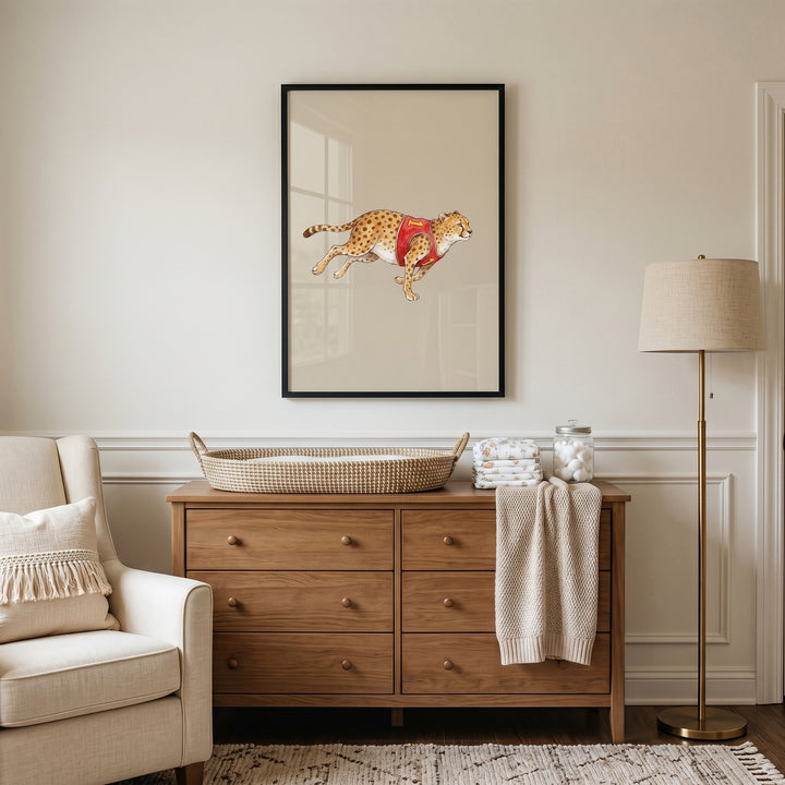 Red jersey running cheetah wall art hangs above a wooden dresser in a neutral nursery with a beige armchair.