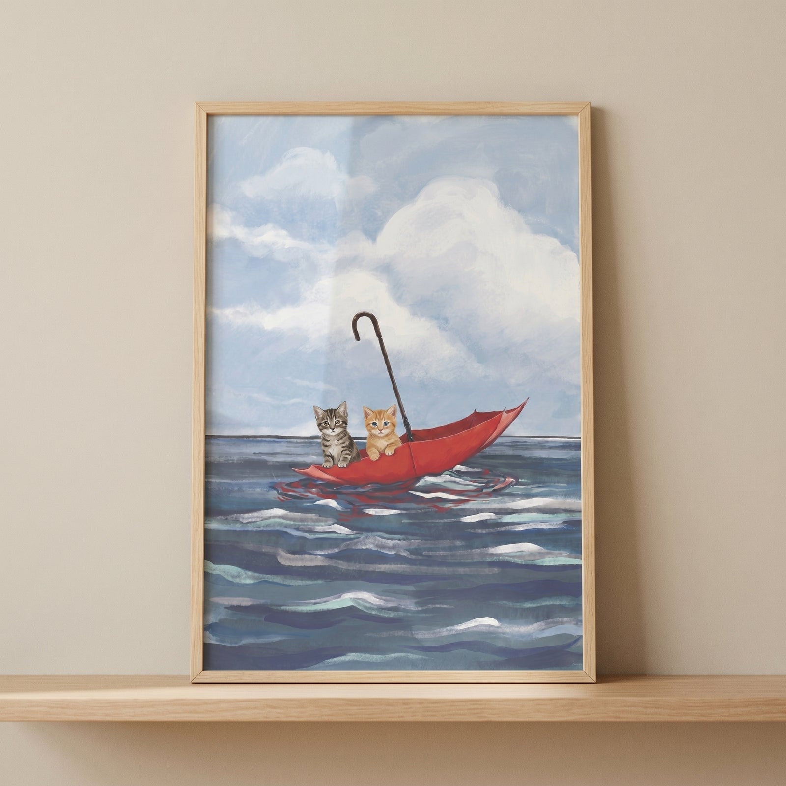 A tabby and ginger kitten float on blue waves in this red umbrella boat kittens wall art under a cloudy sky.