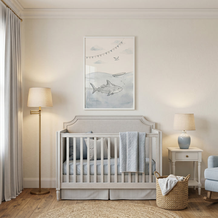 remora fish friendly shark print hangs above a gray crib in a serene nursery with warm lighting and a woven basket.