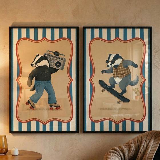Two framed vertical illustrations are displayed side-by-side on a neutral-toned wall. Both pieces share a consistent aesthetic, featuring a background of bold vertical blue and white stripes. Within each, an ornate red border frames a central tan area that highlights a whimsical, anthropomorphic badger character. In the left illustration, the badger is shown in a dynamic pose, as if moving across the frame. It wears a dark long-sleeved shirt and blue trousers, with red and white roller skates on its paws.