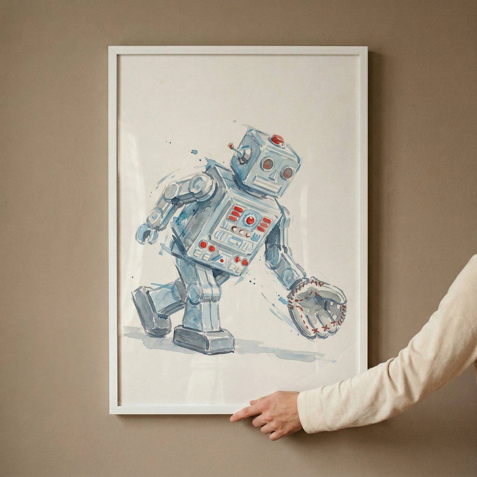 An eye-level shot captures a hand adjusting a white-framed illustration hanging on a neutral, solid-colored wall. The artwork features a stylized, retro-style blue robot rendered with expressive brushwork and ink outlines. The robot is depicted in mid-stride, walking toward the right side of the frame. 