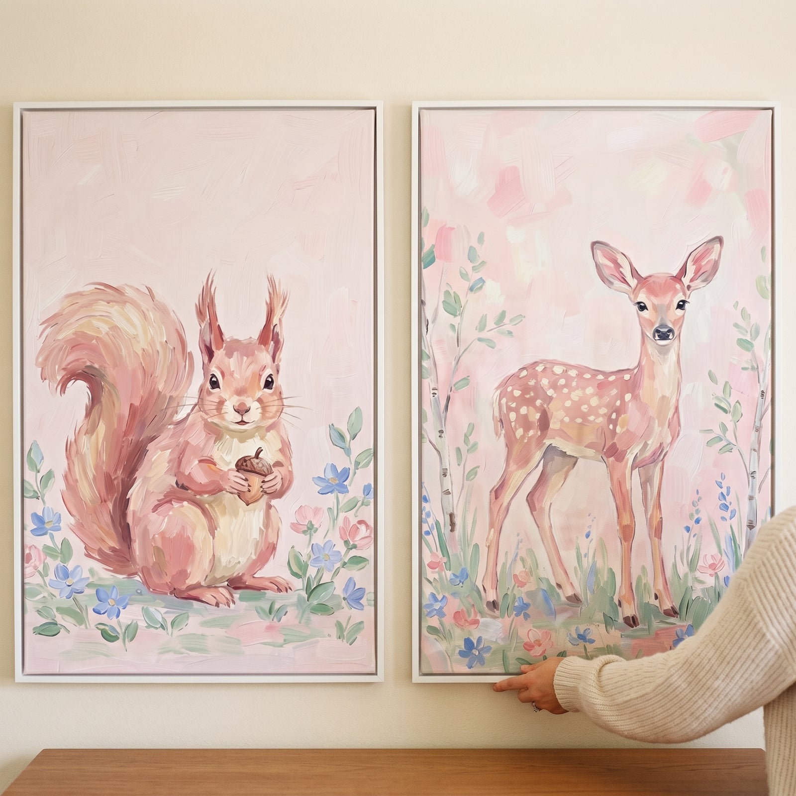 Romantic pink woodland animals wall art set of 2 with a squirrel holding an acorn and a spotted fawn in a floral meadow.