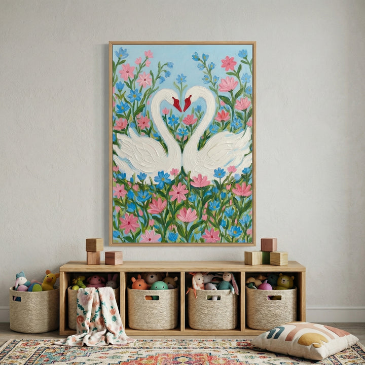 Framed painting of two white swans forming a heart shape with their necks surrounded by pink and blue flowers hangs above a wooden toy shelf filled with baskets of stuffed animals. A soft patterned rug and scattered toys below create a warm playful nursery setting.