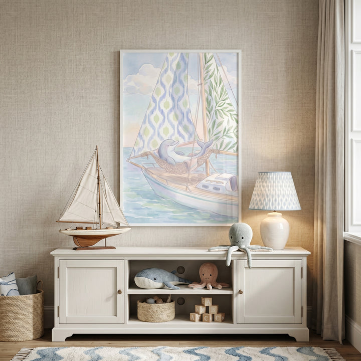 Rope hammock napping dolphin wall art hangs above a white sideboard with a model sailboat, lamp, and plush sea animals.