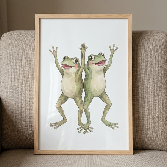Rosy cheek cheering frogs wall art in a wooden frame showing two happy green frogs leaning against a neutral sofa.