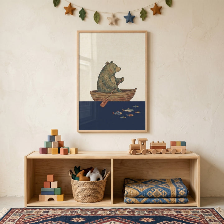 Rowing wooden boat bear wall art above a wooden shelf with blocks, a toy train, and a basket in a neutral nursery.