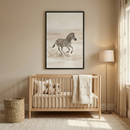 A serene, minimalist nursery in neutral tones features a light wood crib with vertical slats positioned against a beige wall. Inside the crib are soft plush animal toys and a folded cream-colored blanket hanging over the side. Centered above is a large black-framed art piece showing a zebra galloping through a hazy, neutral landscape. To the left is a cylindrical woven wicker basket, and to the right stands a slim floor lamp with a light-colored shade next to long cream curtains.