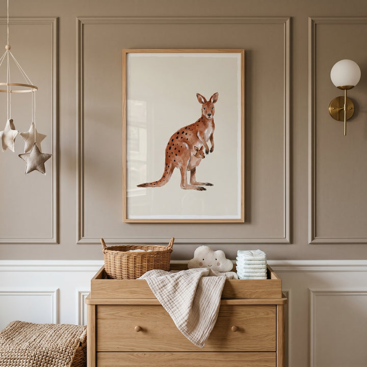 Rust spotted watercolor kangaroo wall art hangs in a neutral nursery above a wooden dresser and star mobile.