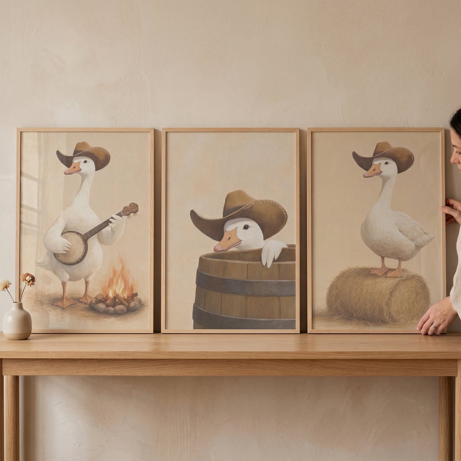 Rustic beige western goose wall art set of 3 featuring geese in cowboy hats with a banjo, a barrel, and a hay bale.