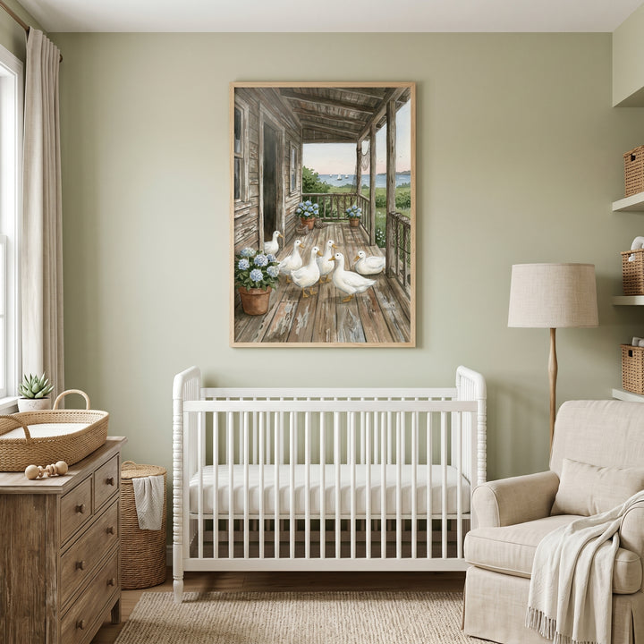 Rustic porch white duck wall art hangs over a white crib in a sage green nursery with a wood dresser and armchair.