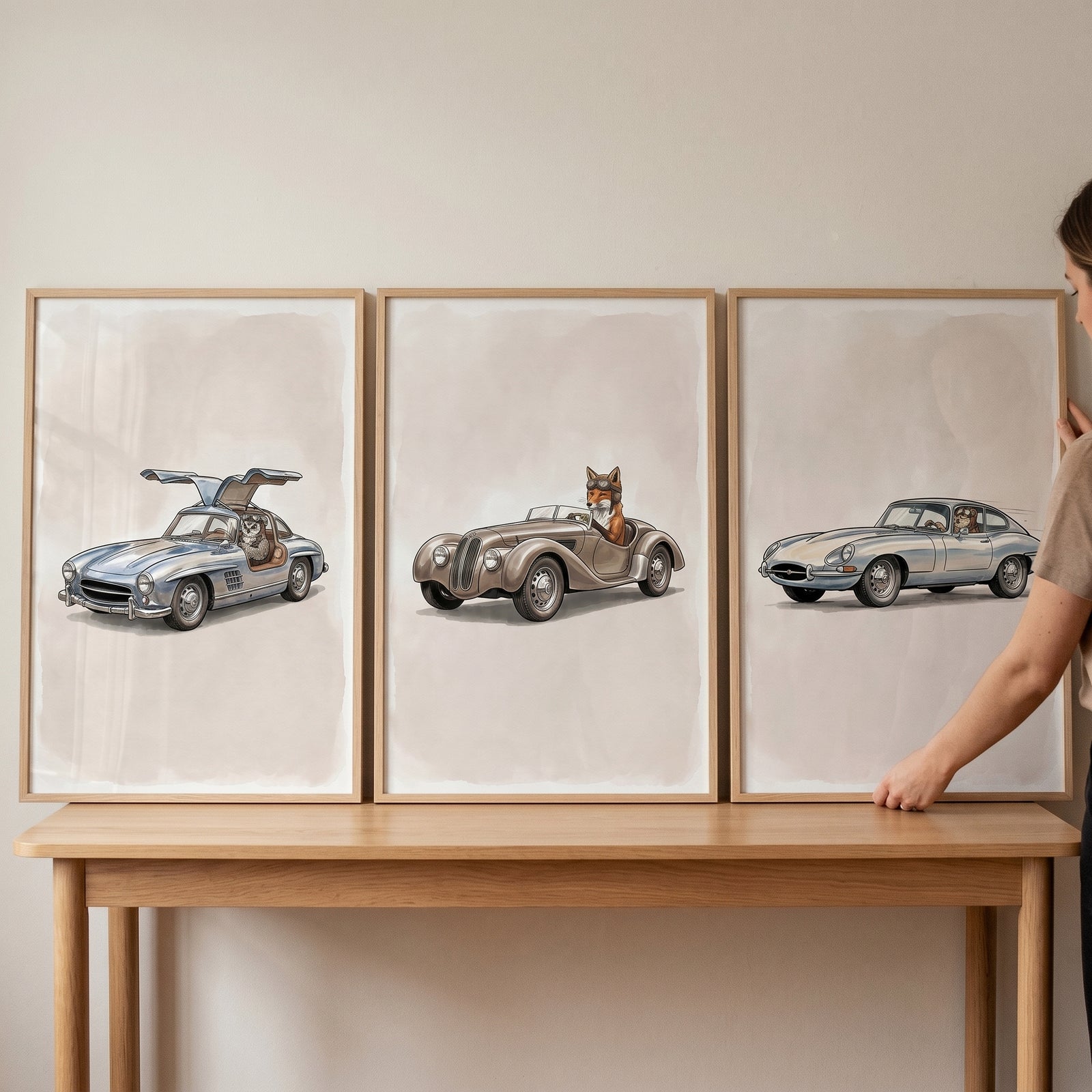 Rustic vintage car animal wall art set of 3 showing a fox and dogs driving classic cars as a person adjusts the frames.