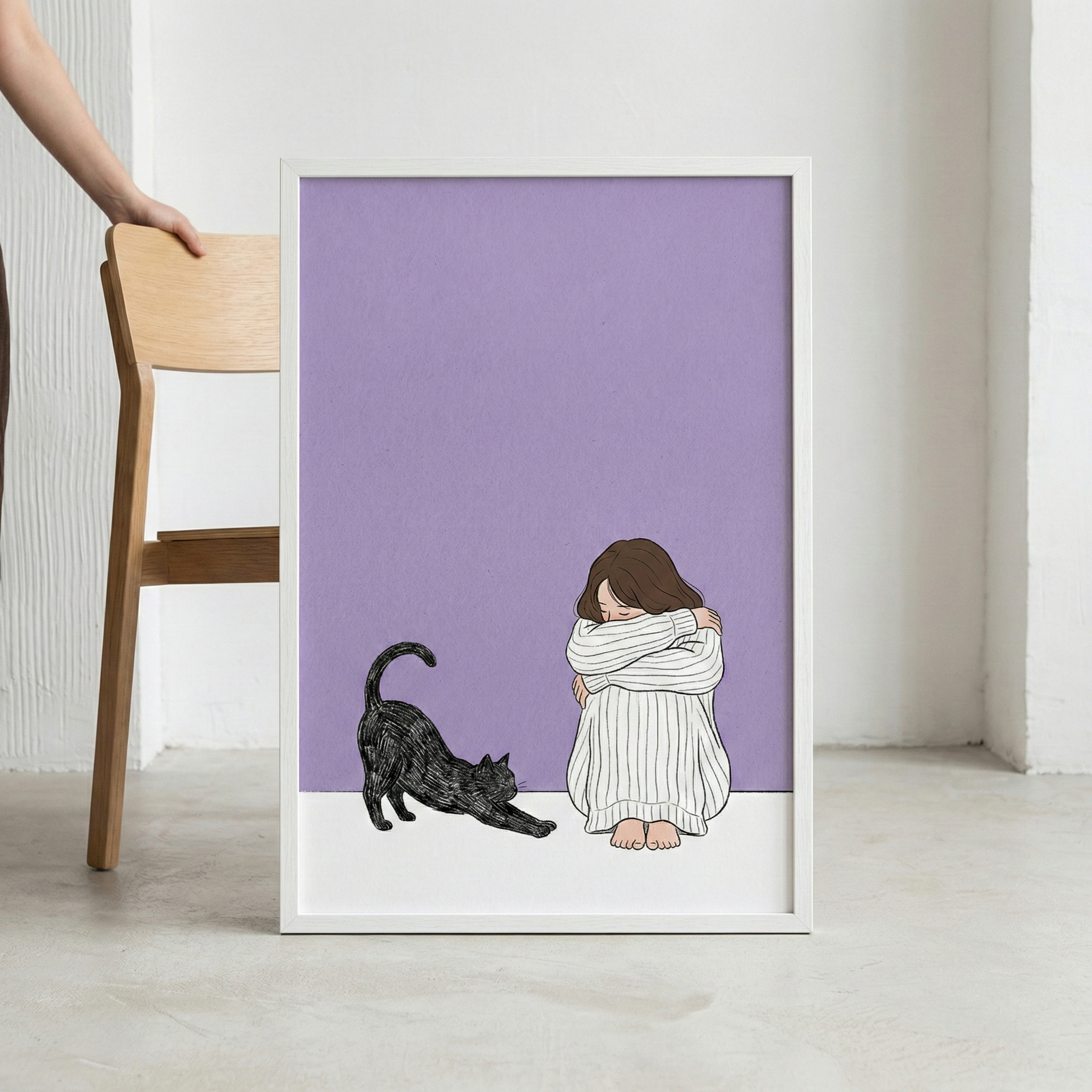 A framed minimalist illustration leans against a white wall on a neutral-toned floor. To the left, a wooden chair is partially visible, with a person's hand resting on its back. The artwork inside the white frame features a solid lavender background. At the bottom of the image, a young person with long brown hair sits curled up on a white surface, wearing an oversized, white, vertical-striped sweater. Their head is tucked into their arms, resting on their knees. 