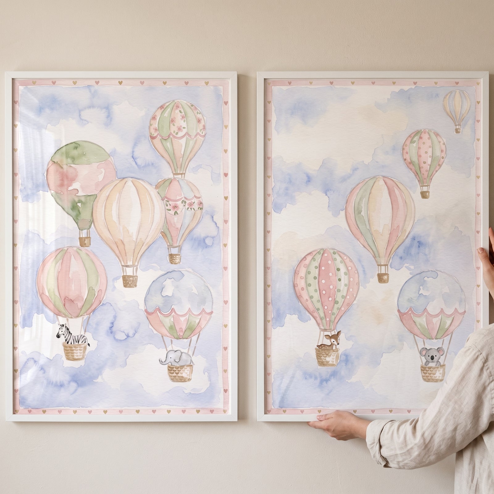 Framed safari hot air balloon wall art set of 2 with animals in pastel balloons against soft watercolor clouds.