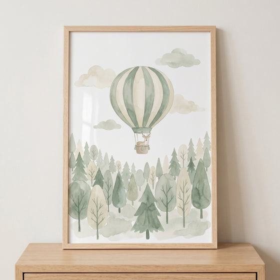 Sage green balloon deer artwork in a wood frame features a deer in a hot air balloon over a watercolor forest.