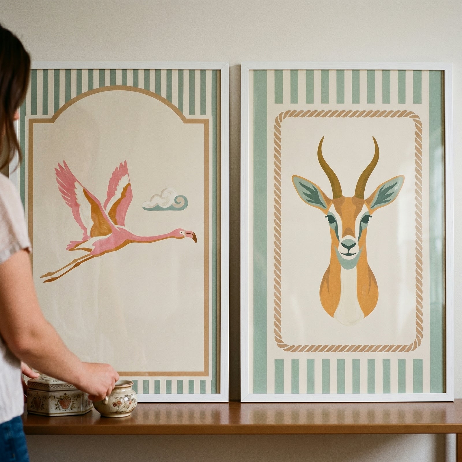 Sage striped safari animals wall art set of 2 features a flying pink flamingo and a gazelle head in white frames.