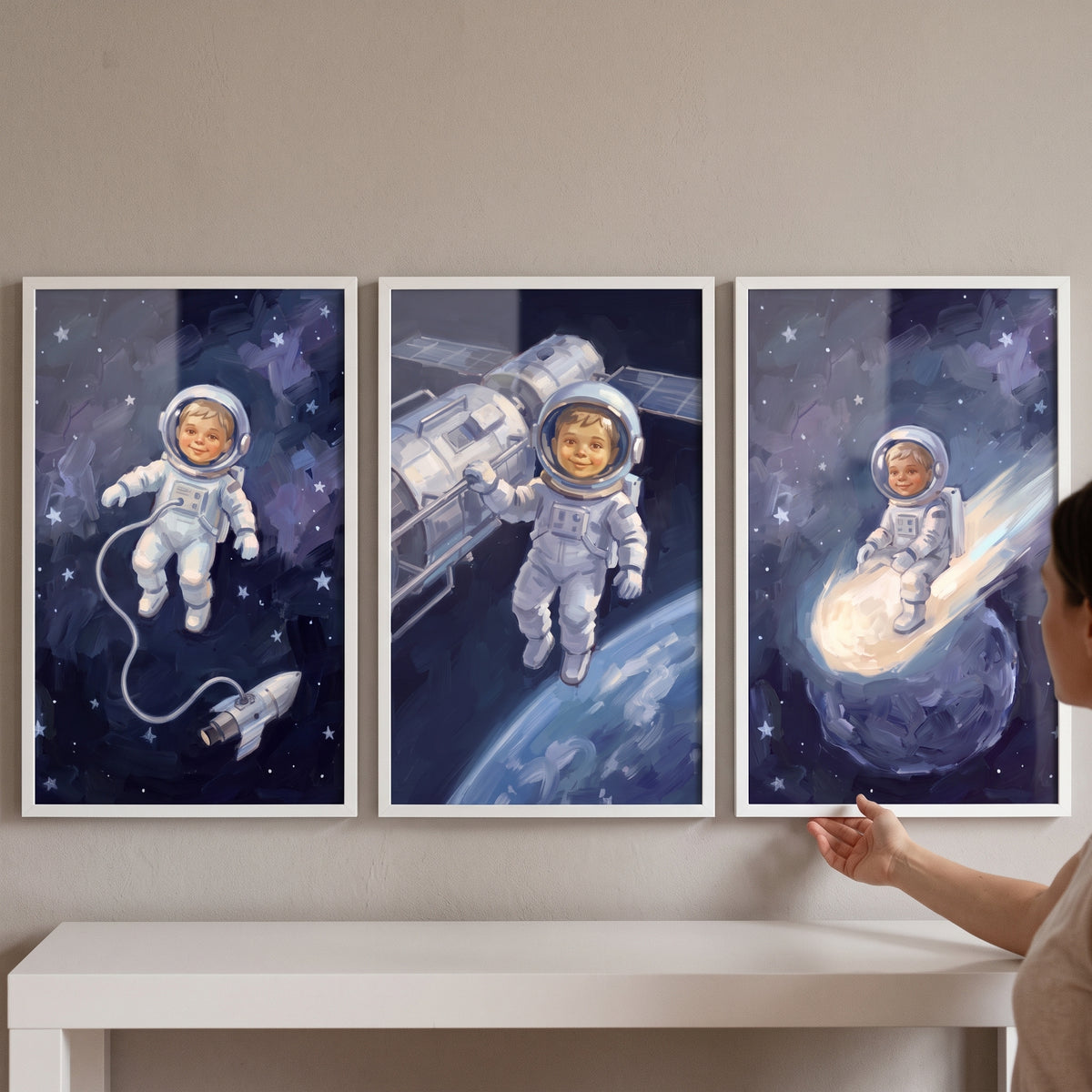 Sapphire starry baby astronaut wall art set of 3 depicts a toddler in spacesuits near a rocket, satellite, and a comet.