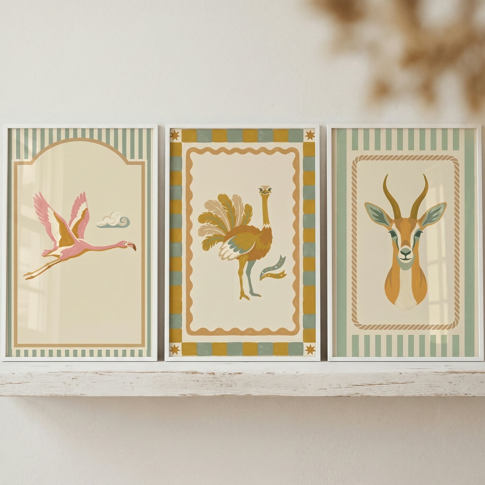 Savanna folk safari animal wall art set of 3 featuring framed prints of a flamingo, an ostrich, and an antelope on a shelf.