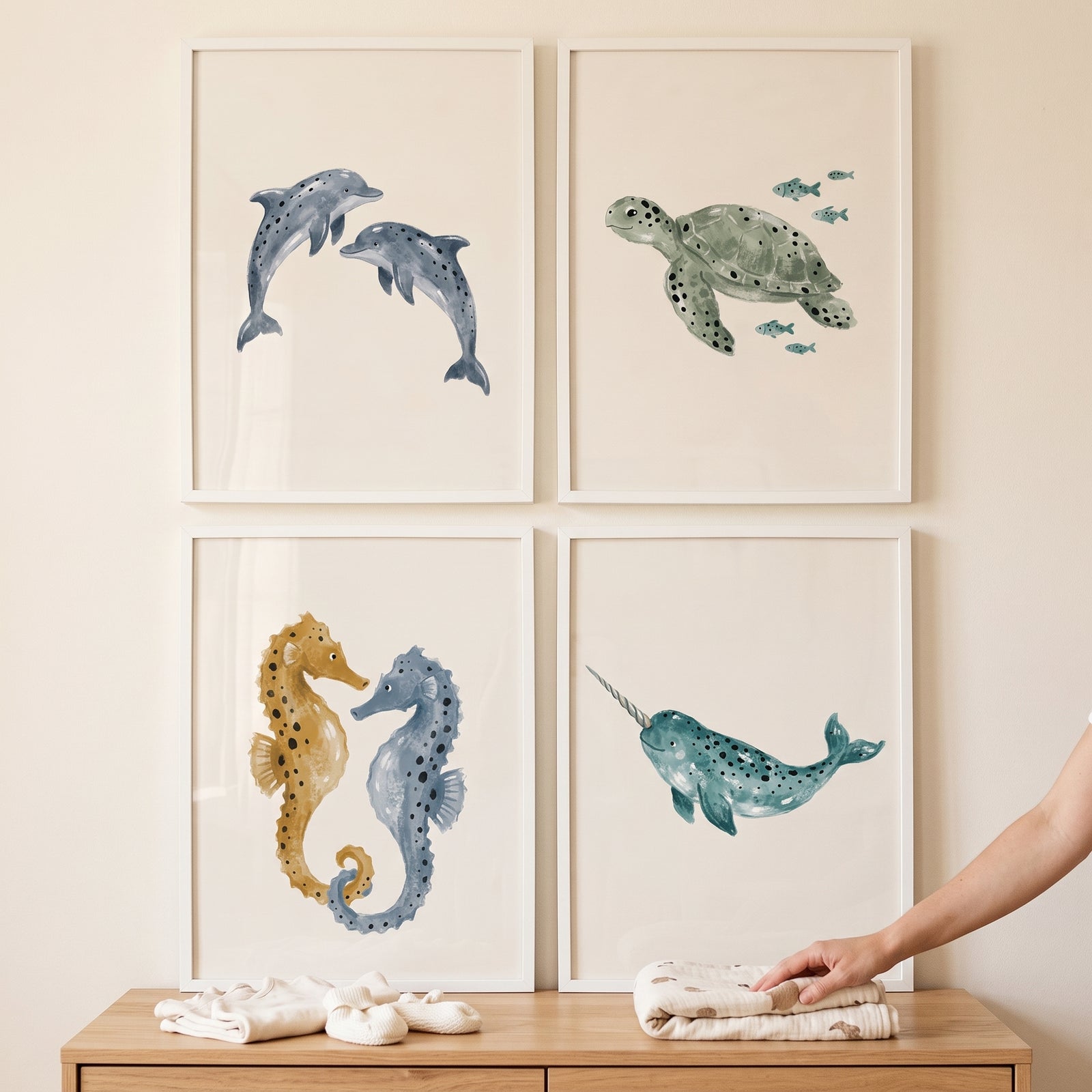 Scandi watercolor sea animal wall art set of 4 with dolphins, a turtle, seahorses, and a narwhal above a dresser.