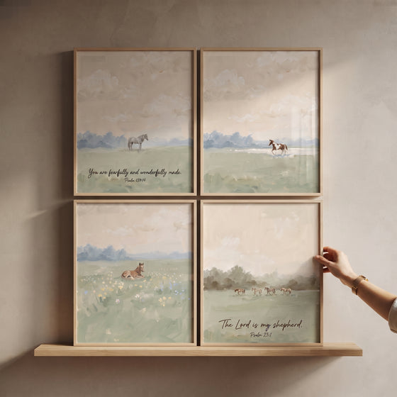 Scenic sage meadow horse wall art set of 4 with scripture verses on a wooden shelf being adjusted by a hand.