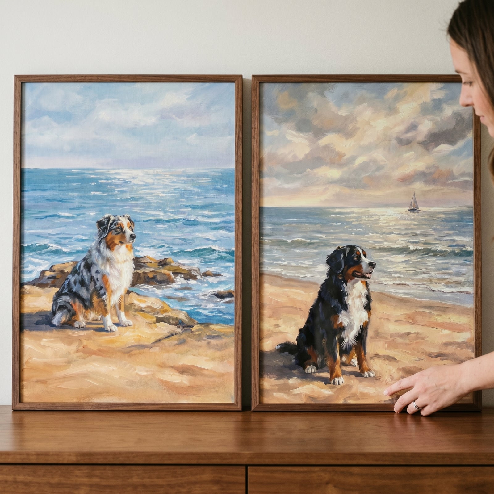 A woman adjusts a scenic seaside sitting dog wall art set of 2 featuring two dogs on sandy beaches by the ocean.